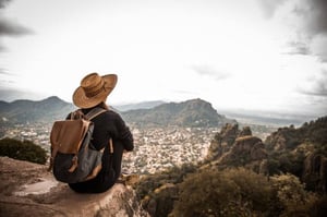 woman sitting on rock admiring view
