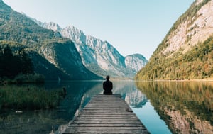 person sitting on dock looking at view