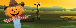 Scarecrow in a feild windmill in the background